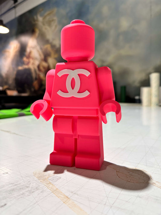 Mini figura Lego rosa con logo CC, realizzata in stampa 3D, ideale per decorazioni artistiche.